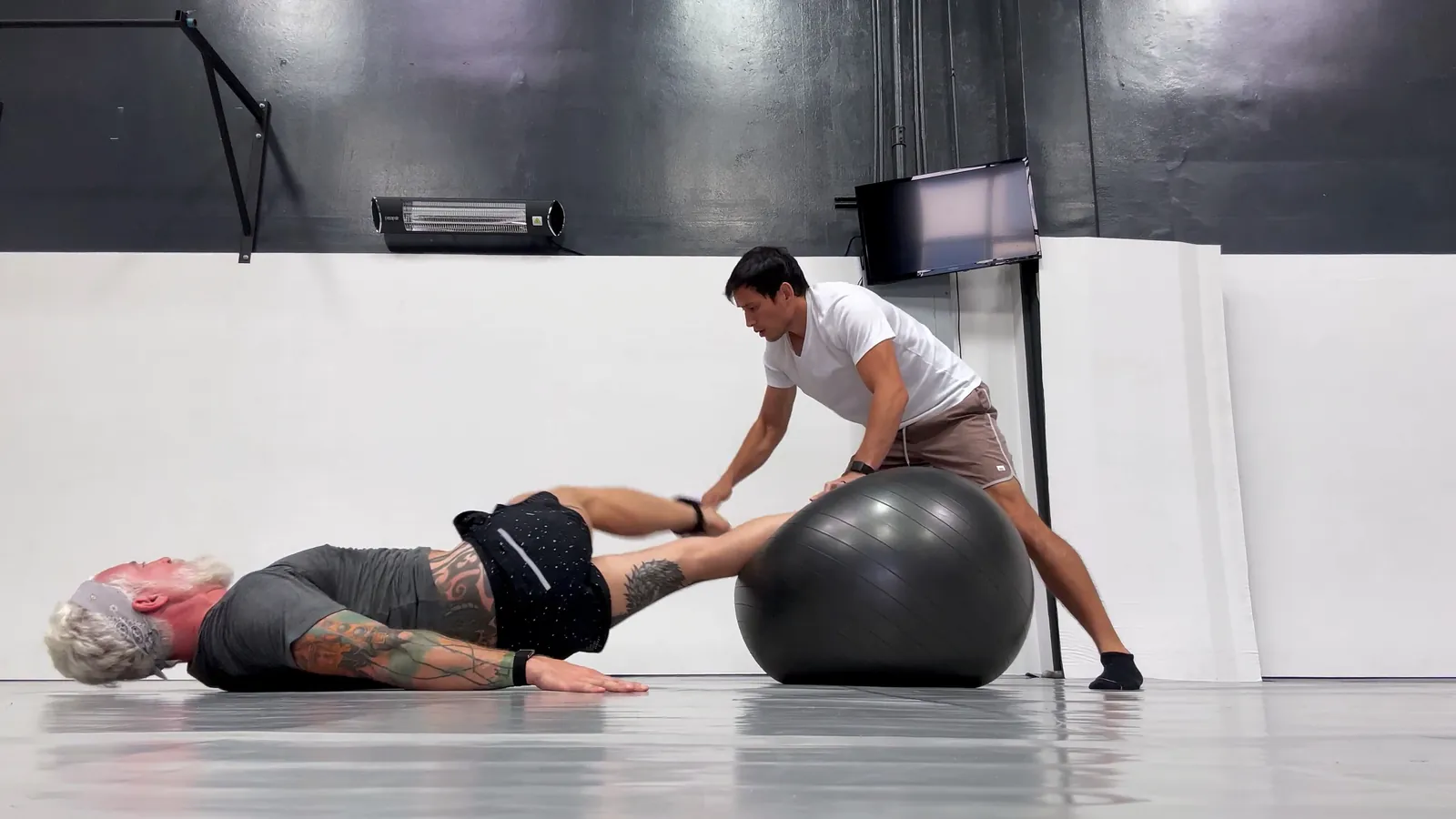 Johnny Faris coaching a client through a stability ball exercise
