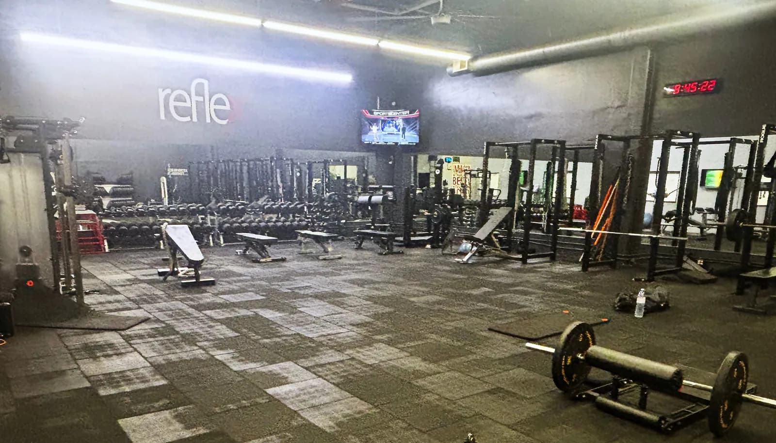 Weight room at the Pasadena gym, with racks, barbells, and dumbbells